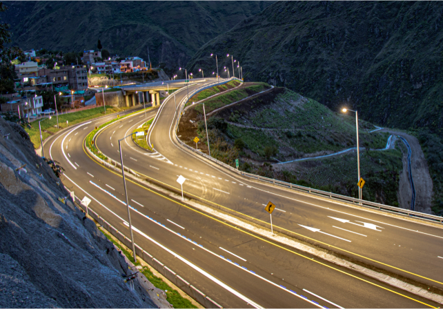 Winding mountain road illuminated by street lamps at dusk