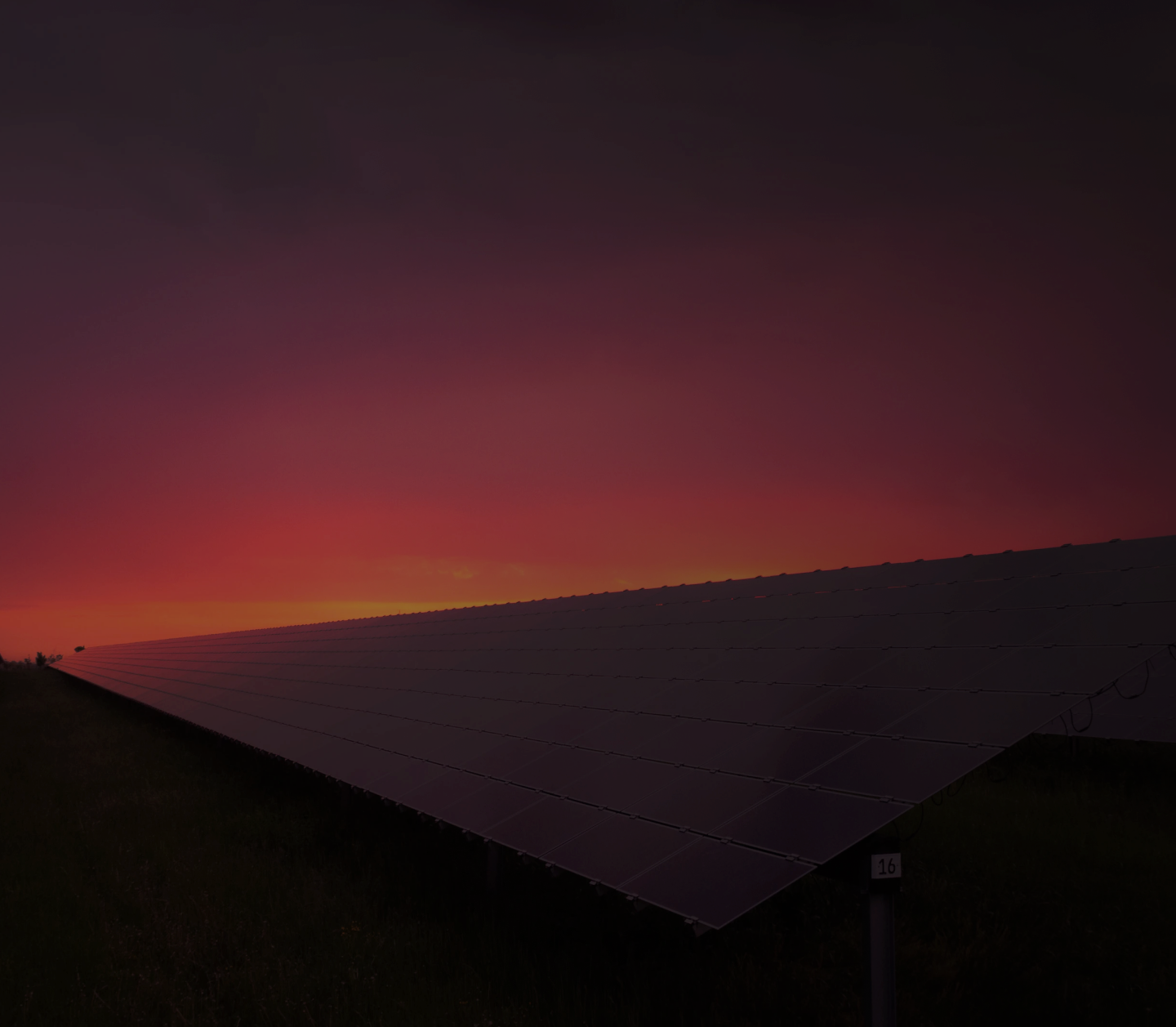 Silhouette of a large solar panel array at sunset